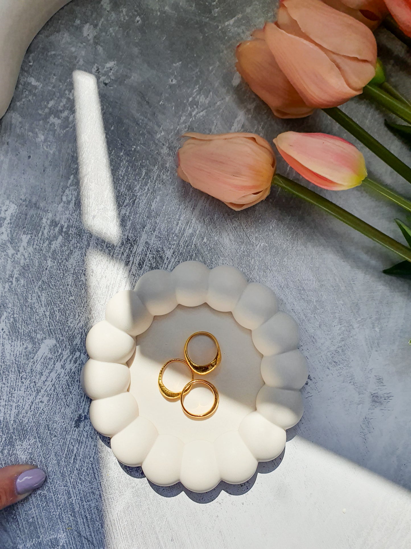 Bubble Jewellery Holder with gold rings on it Tulips on the side on a grey background