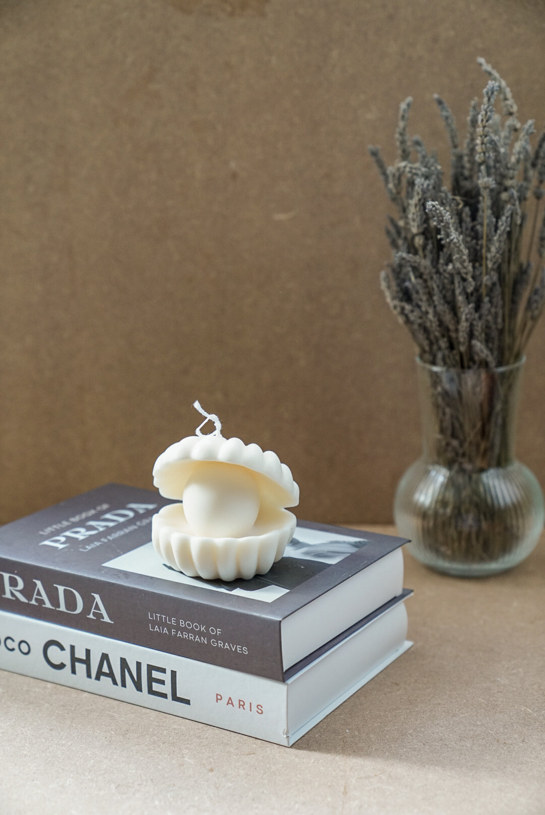 Large Clam Shell W/ Pearl Candle on a magazine.