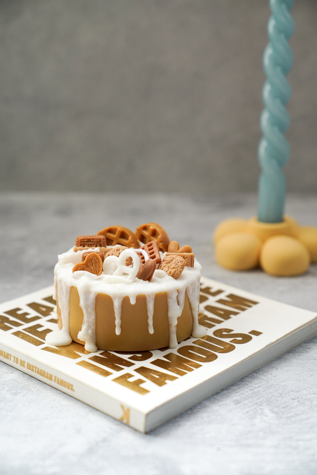 Not edible chocolate Birthday Cake Candle on a magazine with twisted candle on the background son a flower candle holder.