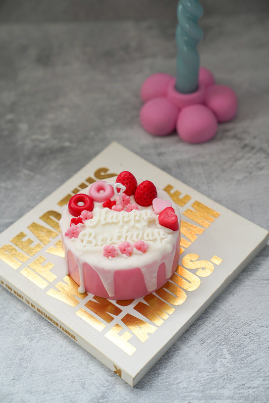 Happy Birthday Cake Candle with raspberries it and flower candle holders on the back.