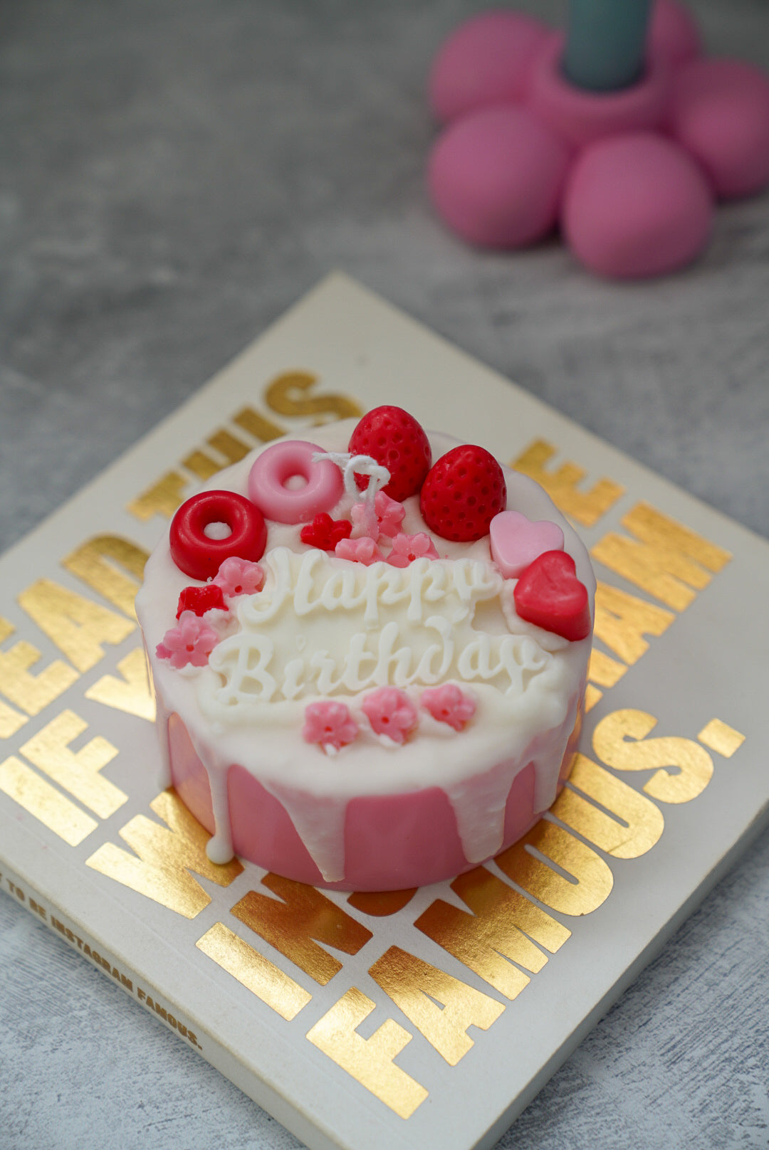 Happy Birthday Cake Candle with raspberries it and flower candle holders on the back.