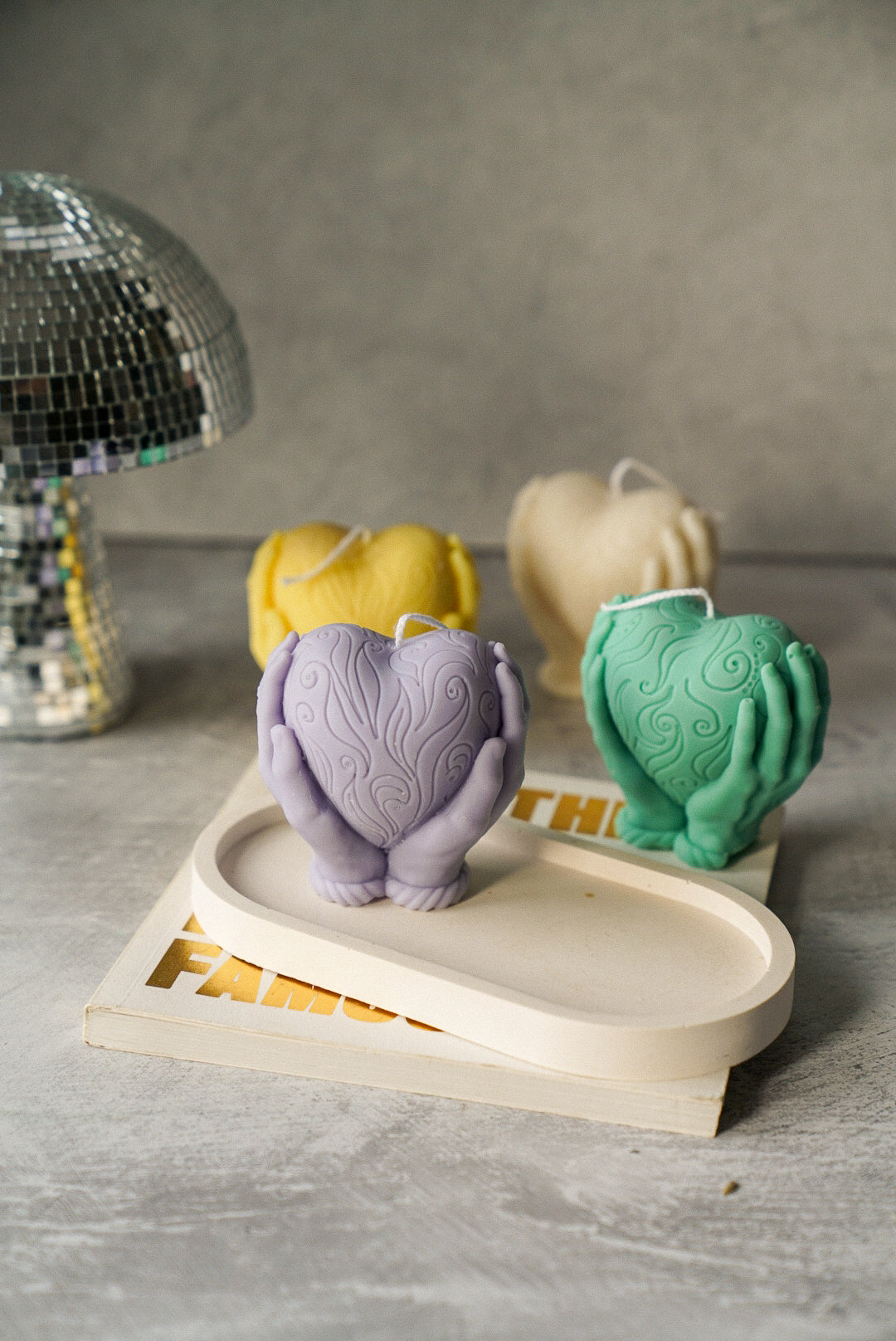 Hands Holding A Heart Candle in a oval trinket tray.