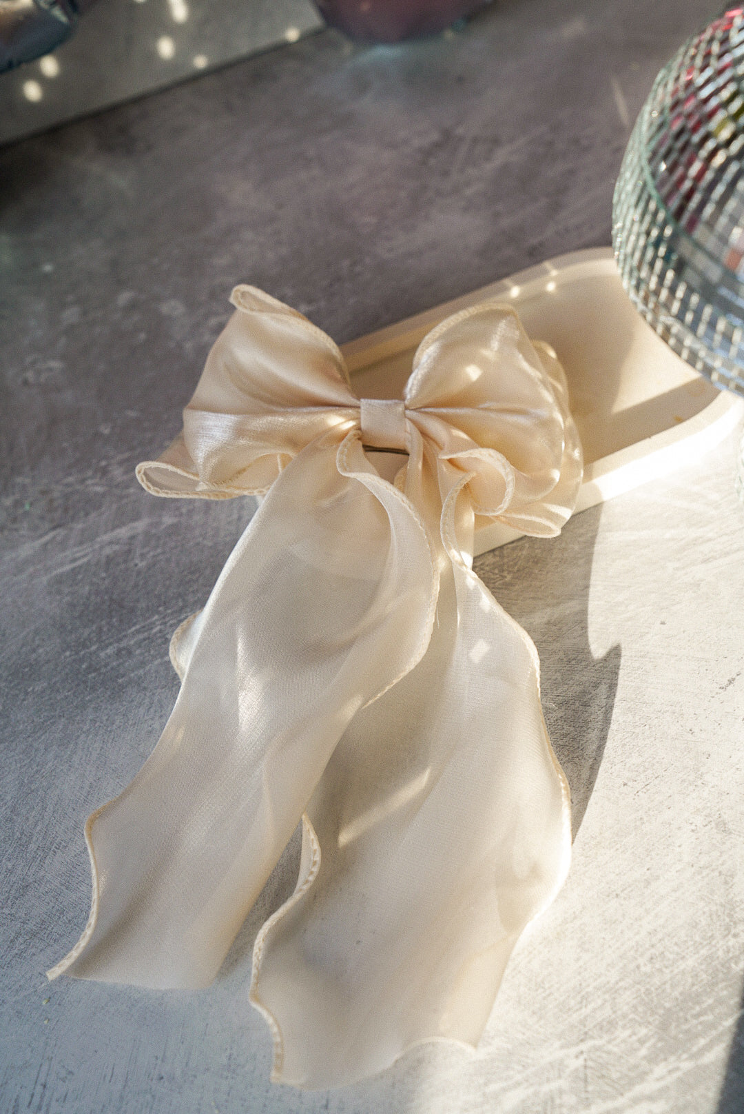 Cream Bow Tie Hair Clip on a trinket tray