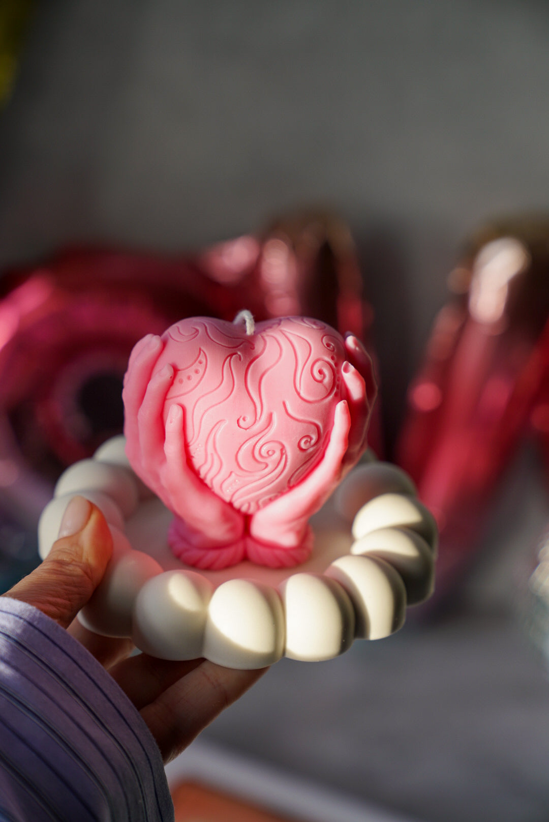 Hands Holding A Heart Candle in a bubble trinket tray.