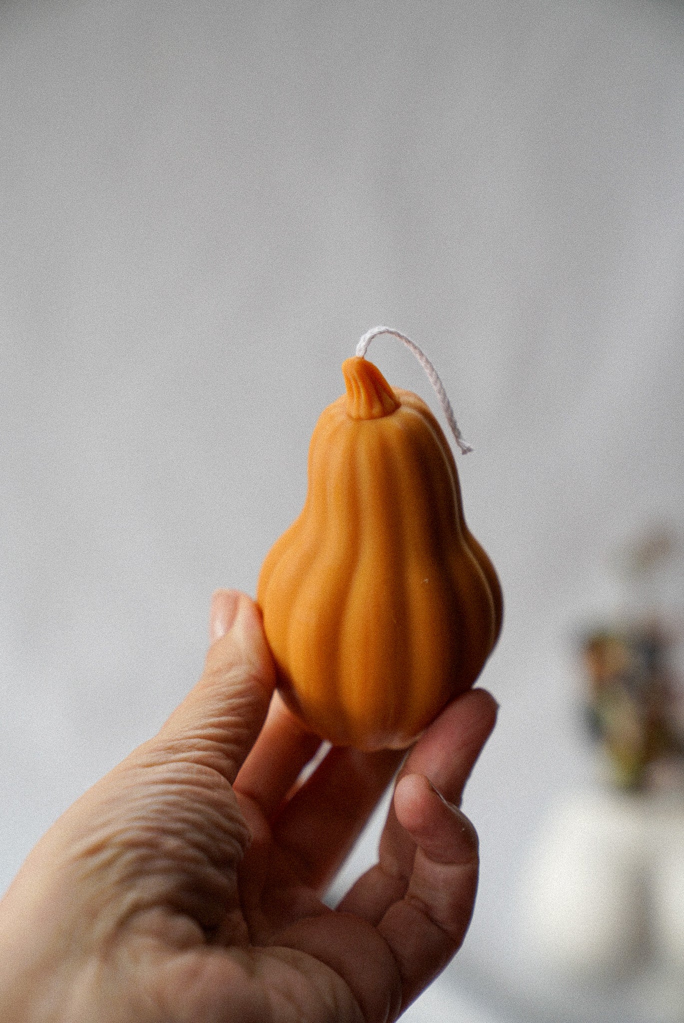 Holding Halloween Pumpkin shaped candle.