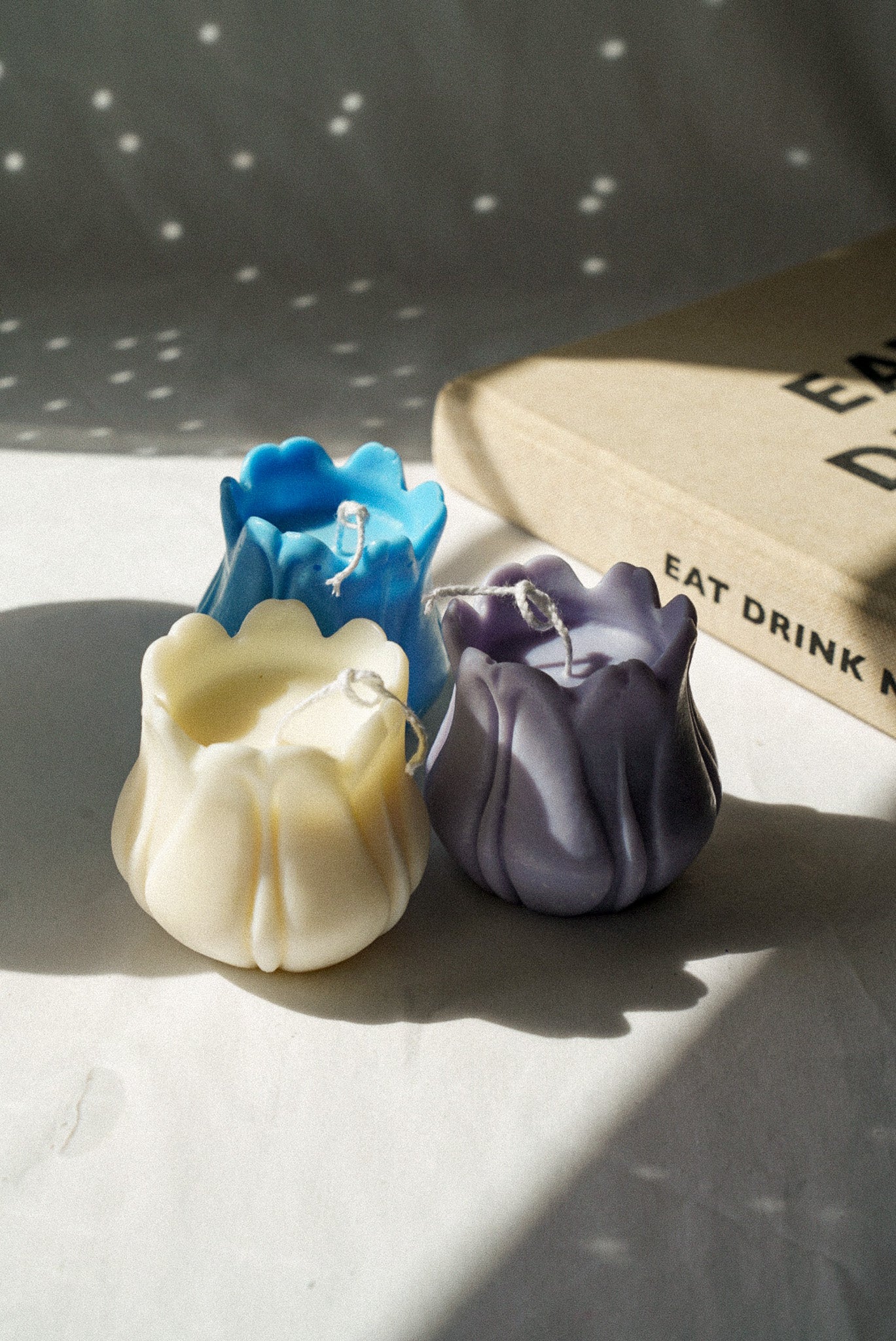 Three Tulip Shaped Soy Wax Candles with magazine on the background.