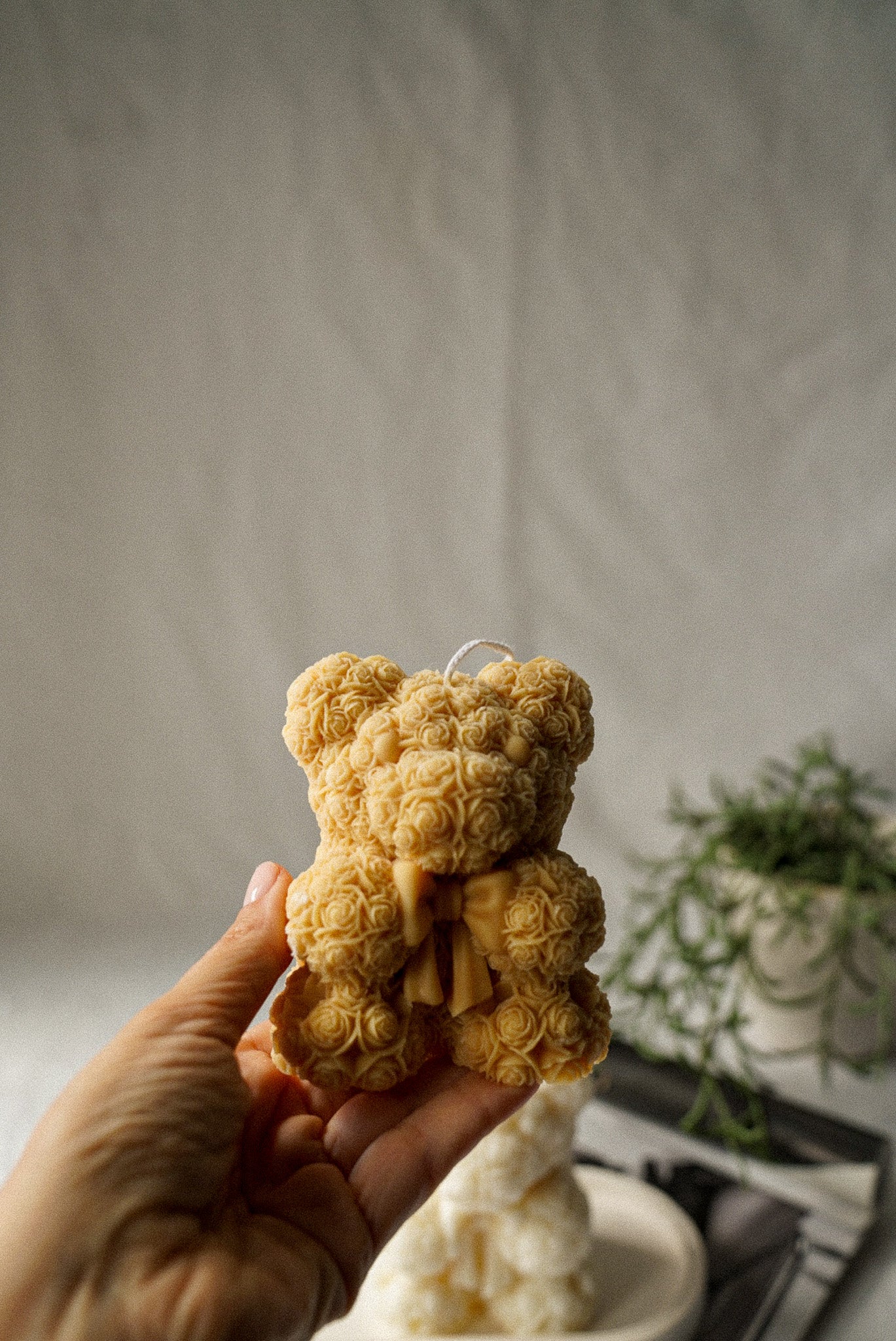 Holding Brown Flower detailed teddy candle with bow