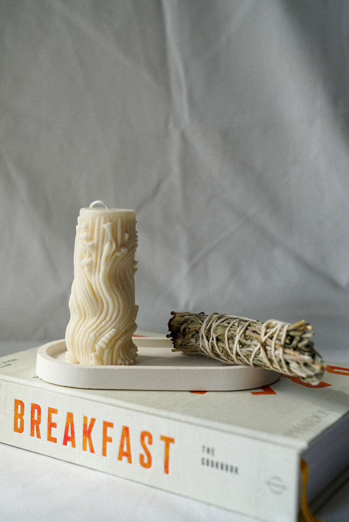 Carved Cylindrical Pillar Candle with sage stick next to it