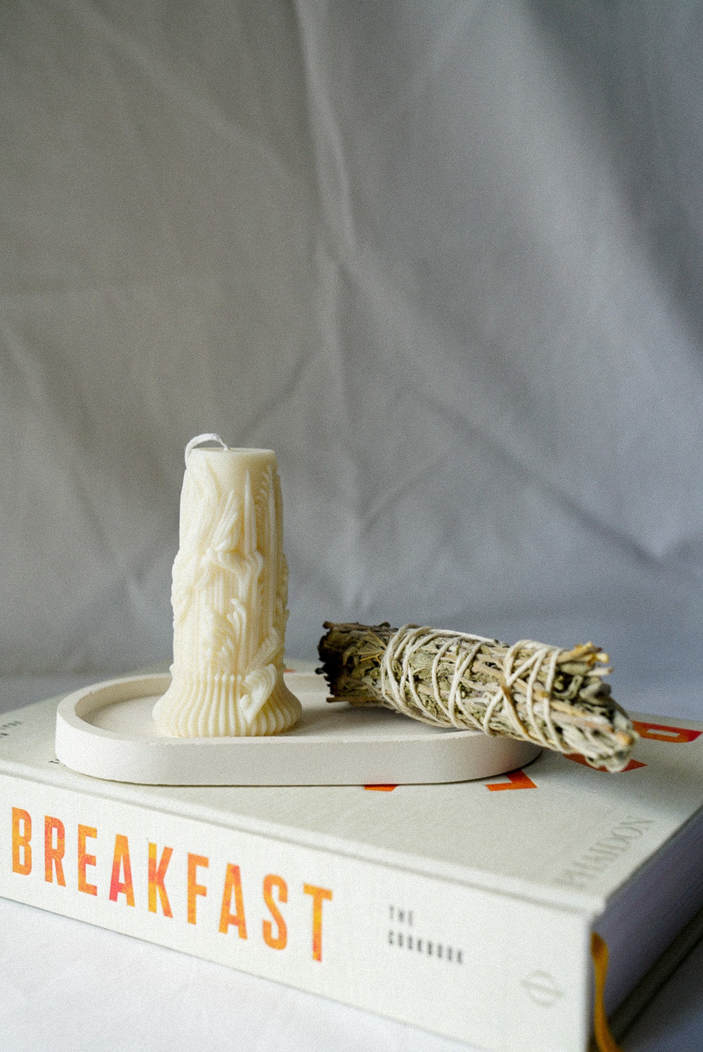 Carved Cylindrical Pillar Candle with sage stick next to it