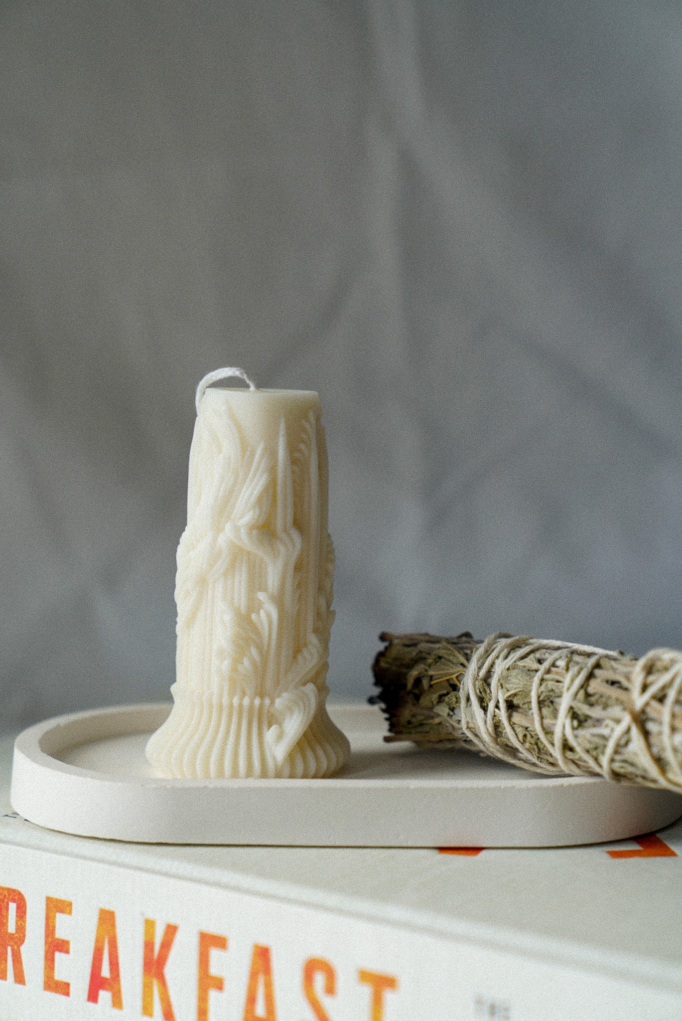 Carved Cylindrical Pillar Candle with sage stick next to it