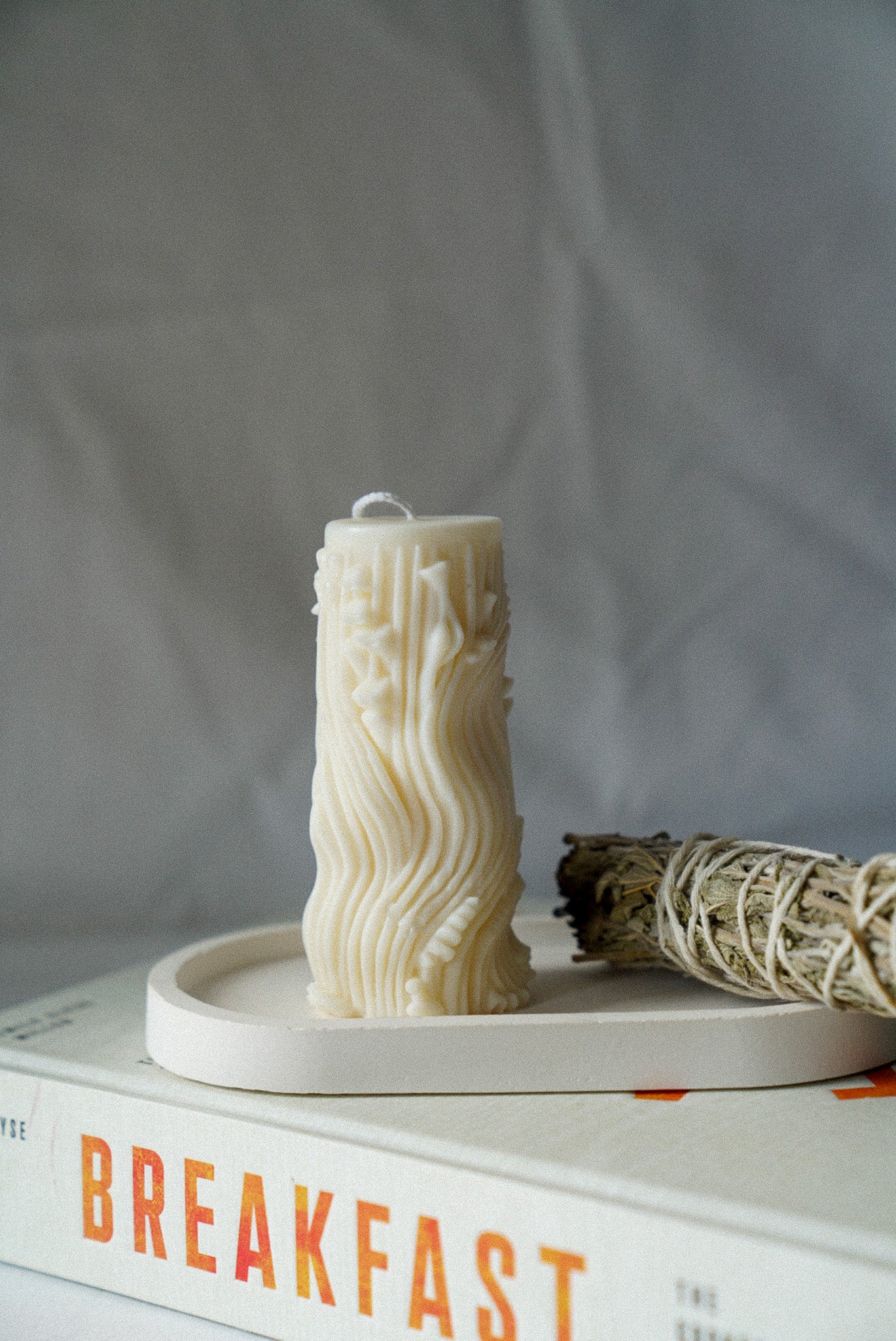 Carved Cylindrical Pillar Candle with sage stick next to it