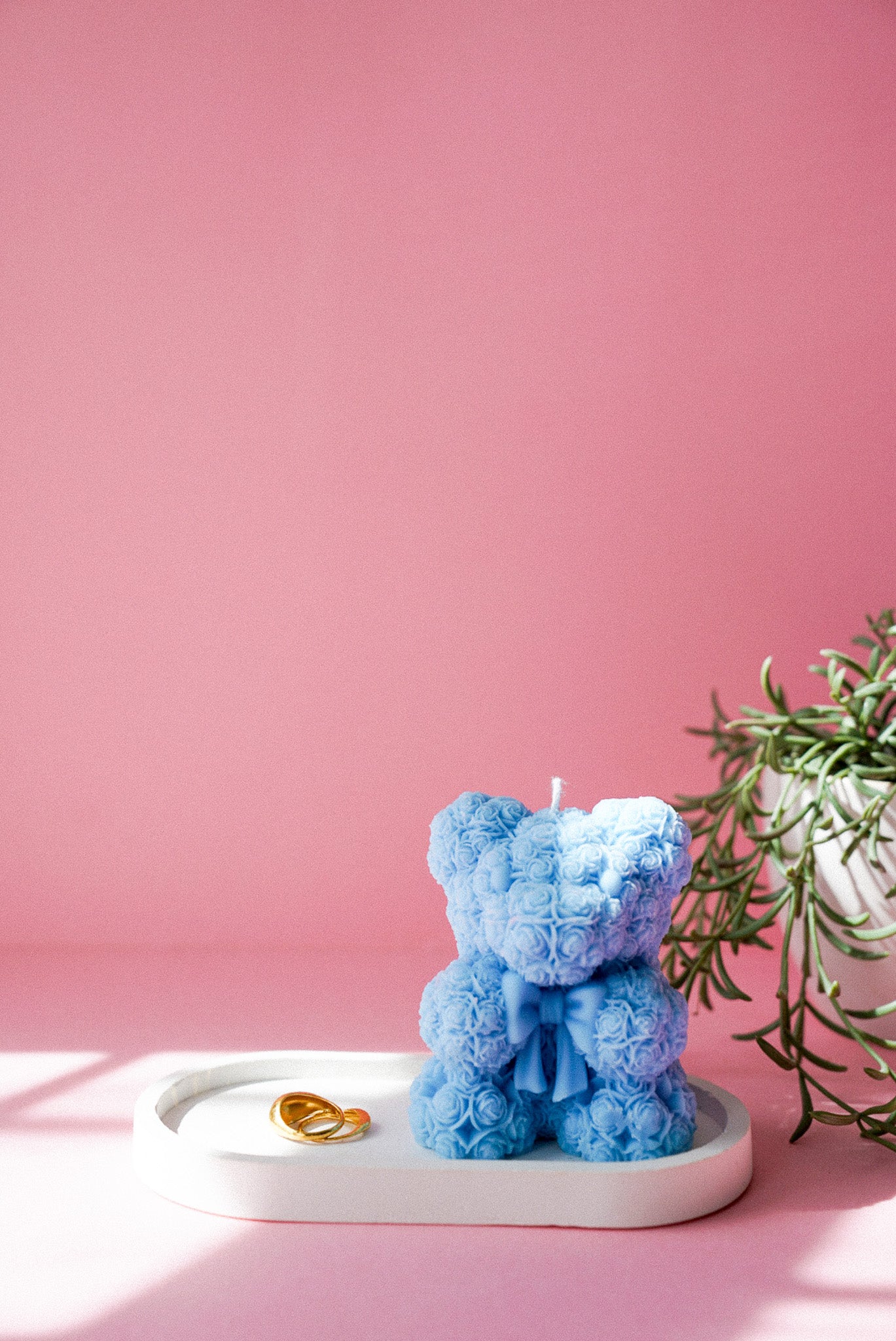 Blue Flower detailed teddy candle with bow on sitting on a trinket tray