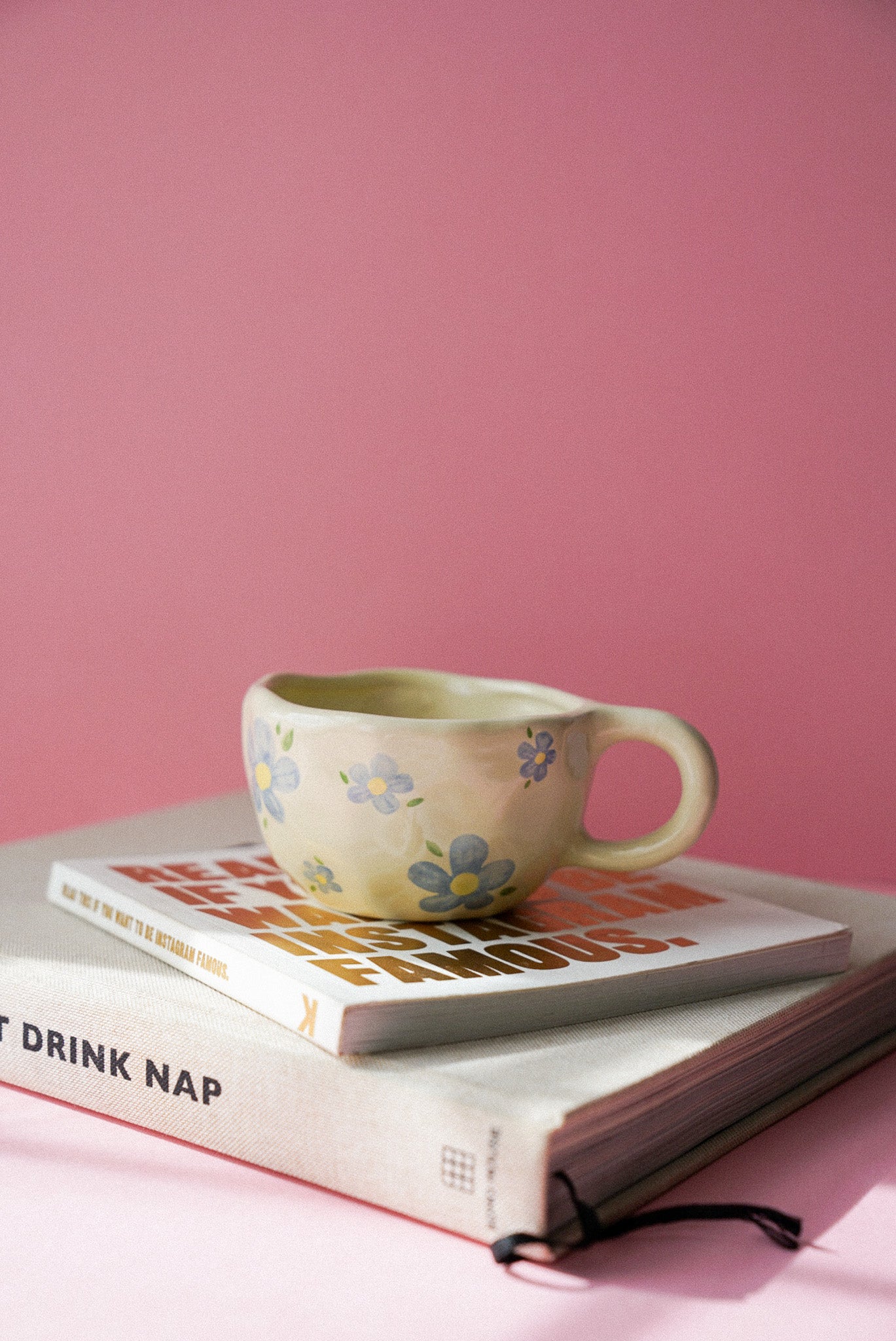 Blue Flower Ceramic Coffee Cup / Tea Mug sitting on a magazine