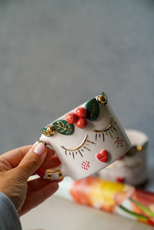 Holding a coffee mug on a grey background.
