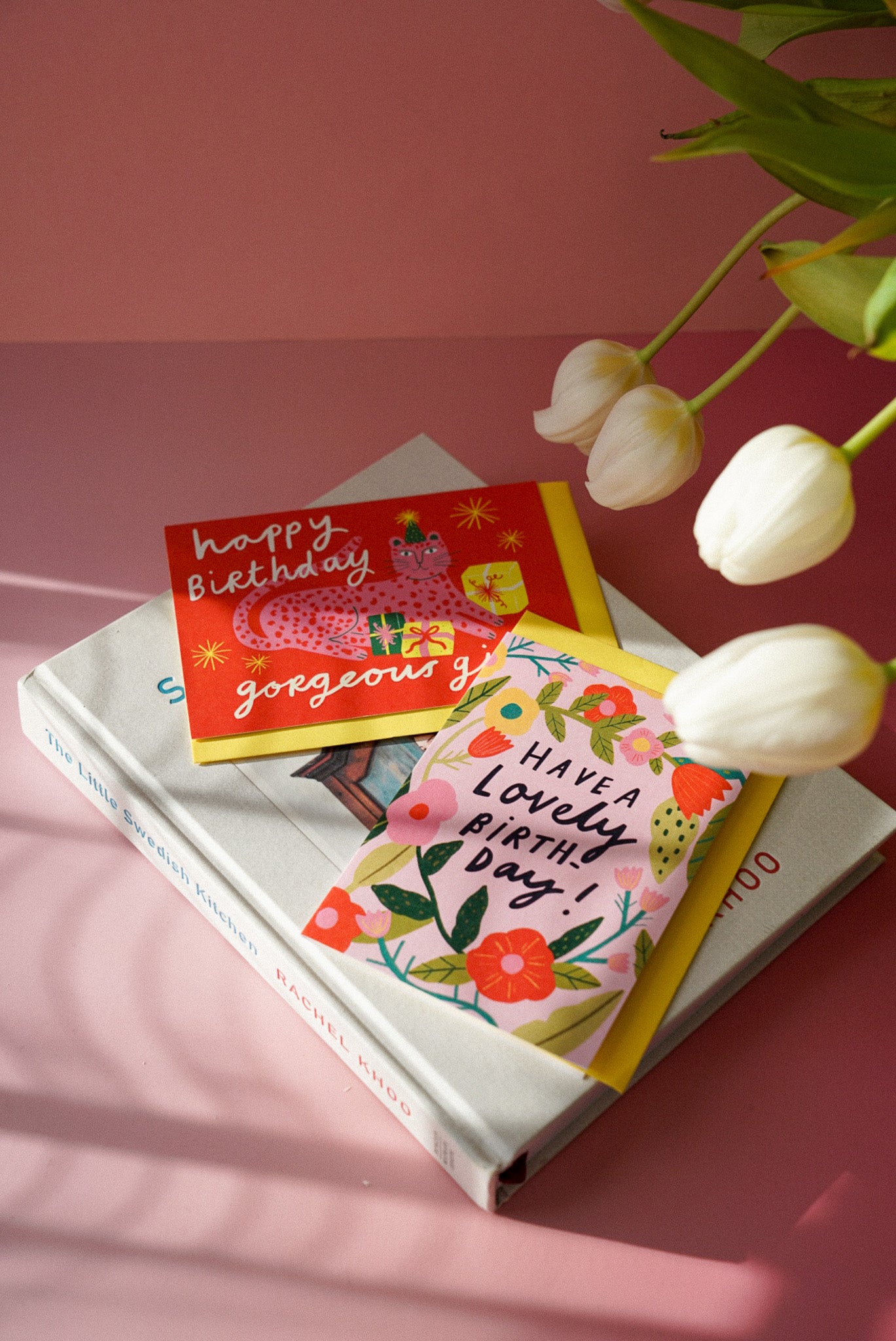 two birthday cards sitting on the book