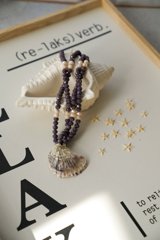 Necklace with shell pendant on a decorative background