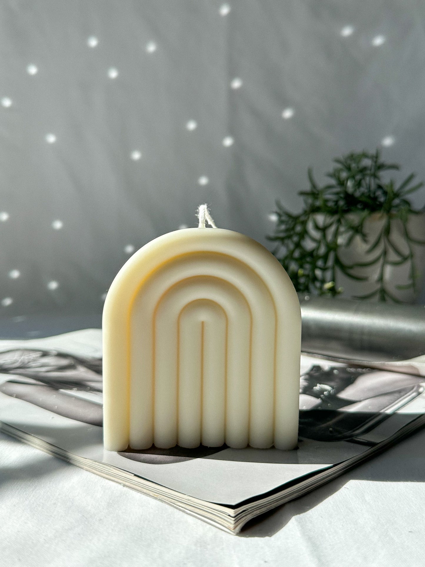 Ivory Arch Rainbow Soy Wax Candle on a magazine