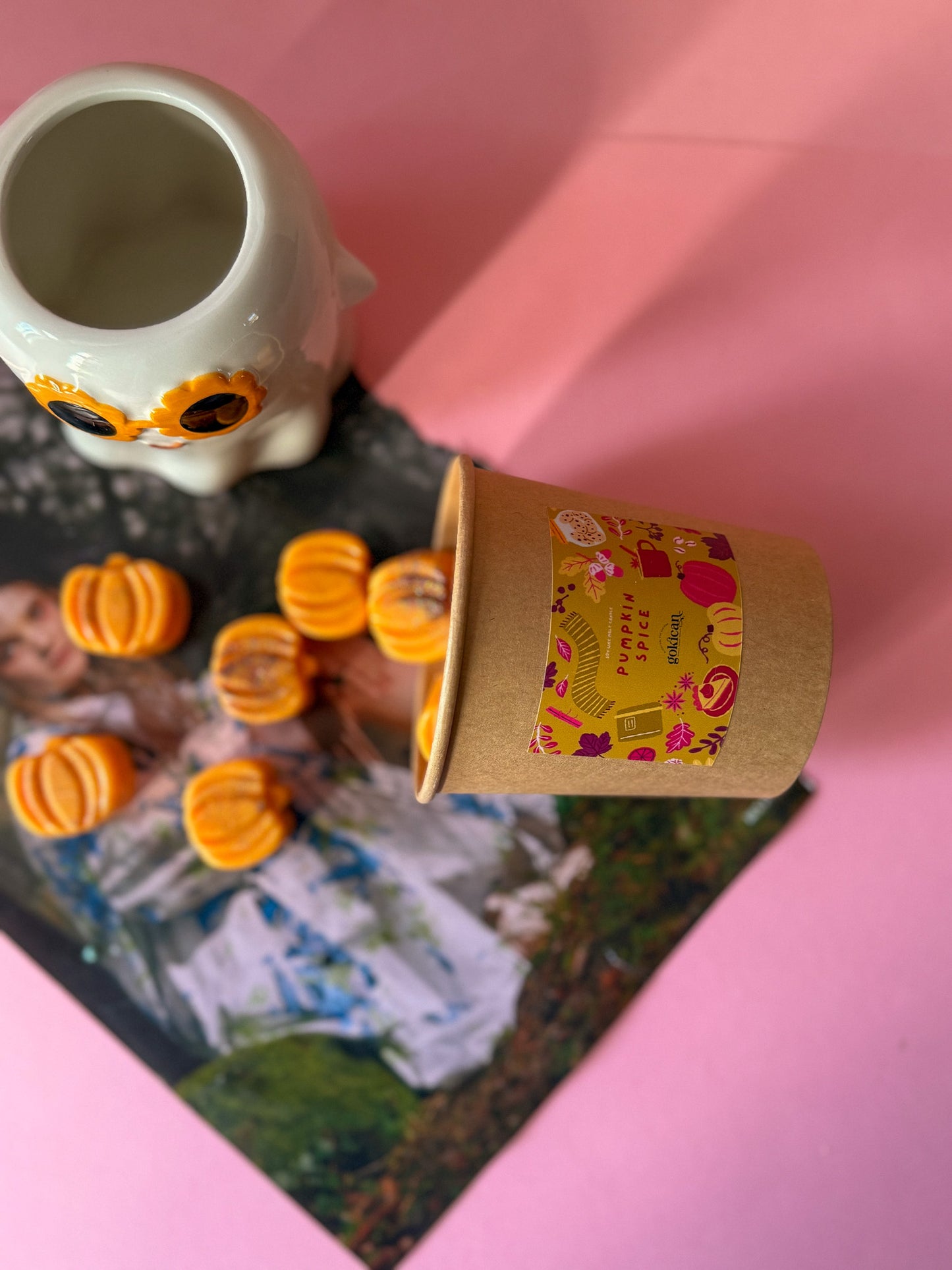 Small cardboard cup with a colorful design on a pink surface