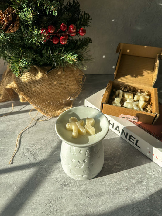 Christmas Spice Wax Melts with White Butterfly Wax MelterChristmas Spice Wax Melts with White Butterfly Wax Melter with Xmas tree on the background.