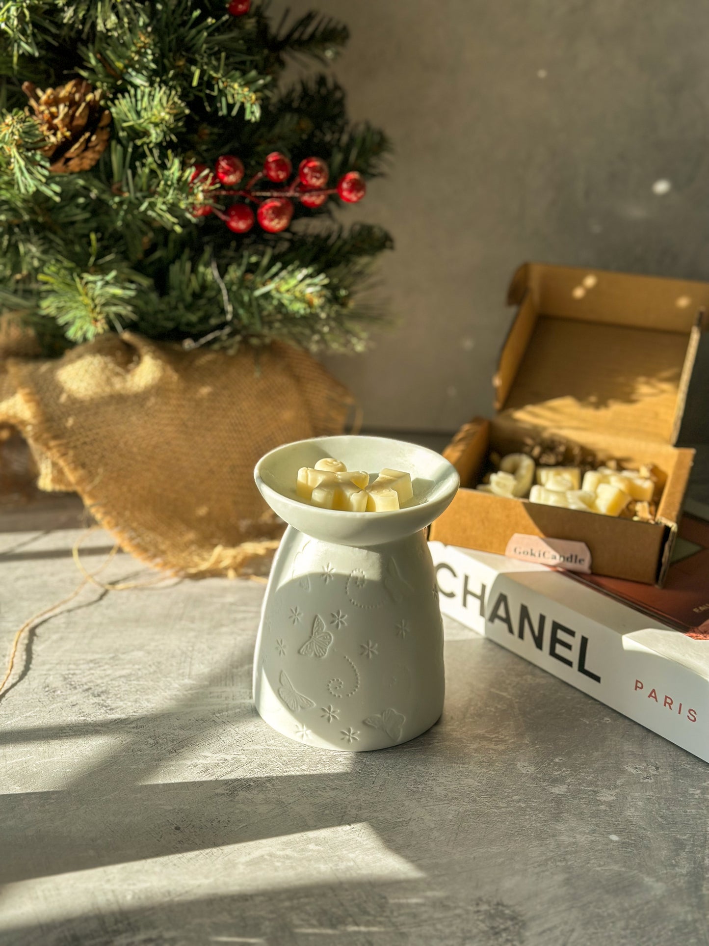 Gingerbread shape Wax Melts with White Butterfly Wax Melter and Christmas Tree on the background.