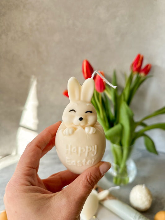 Holding Easter Bunny Candle 2 ears up and tulips are on the background.