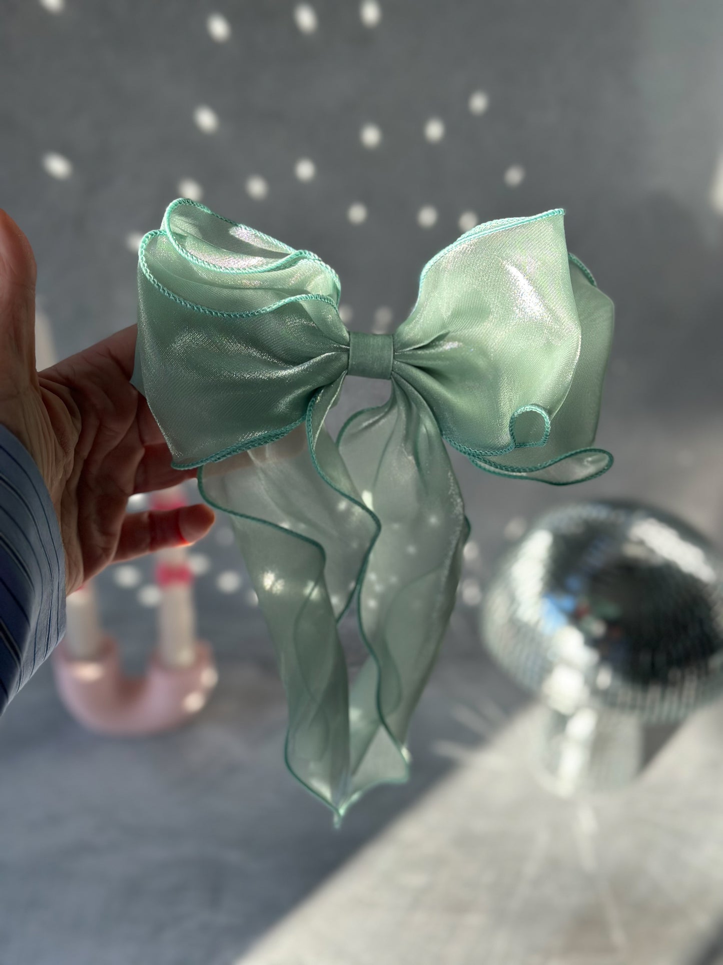 Holding Green Bow Tie Hair Clip