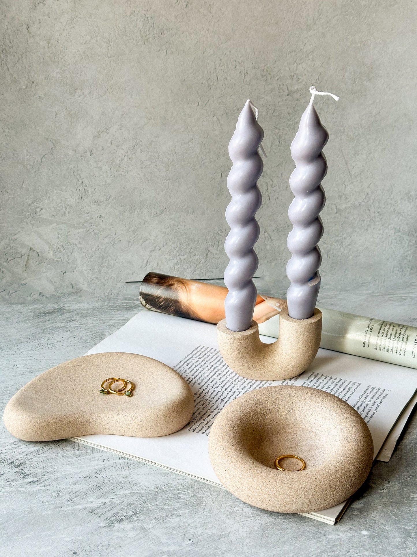 Earthy round Asymmetric Stone Texture Jewellery Tray with U shape candle holder and twisted candles on the background.