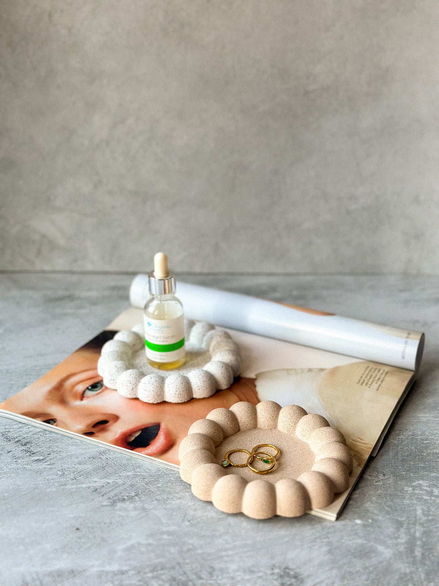 Earthy Bubble Stone texture Jewellery Tray with jewellery on it and some facial products on the other jewellery dish.