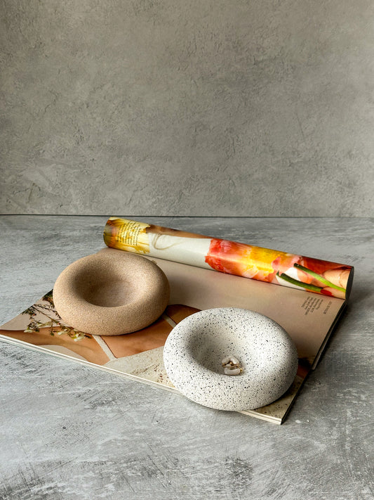 Round Asymmetric Stone Texture Trinket Trays on a magazine.