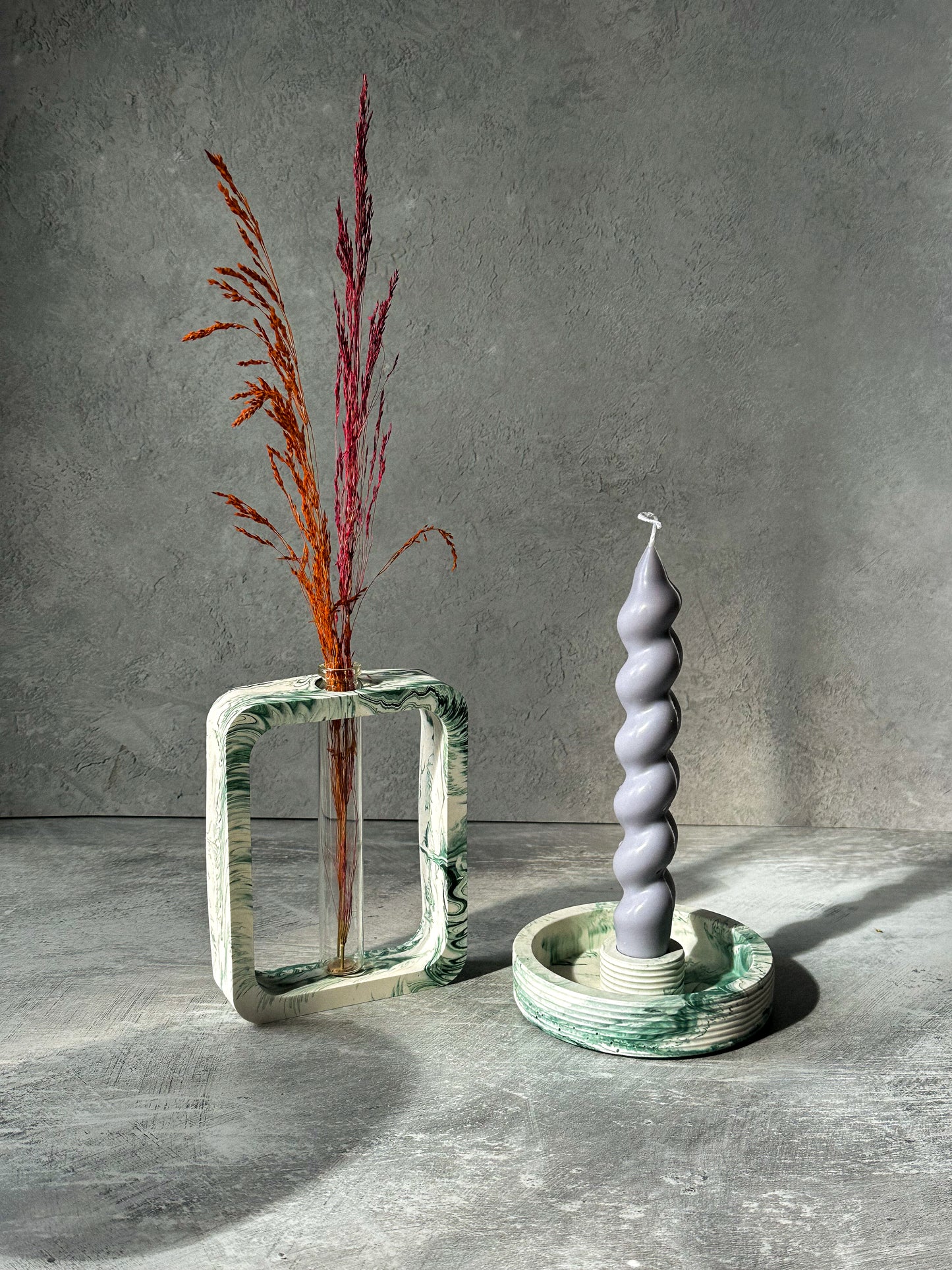 Handmade Holo Vase with dry flowers in it with twisted candle next to it.