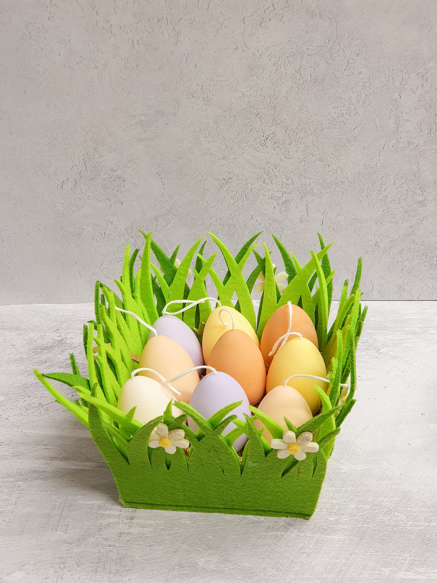 Easter Egg Candles on a green fabric decor.