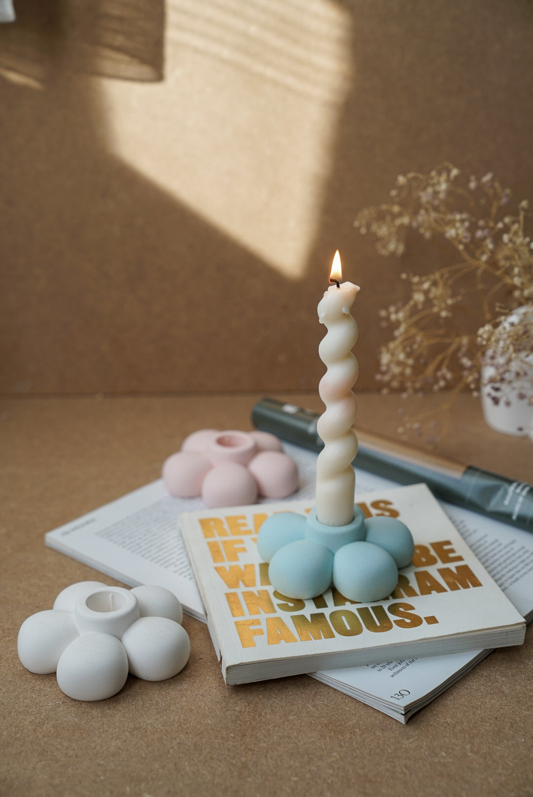 Flower Shaped Candle Holder with twisted burning candle on it.