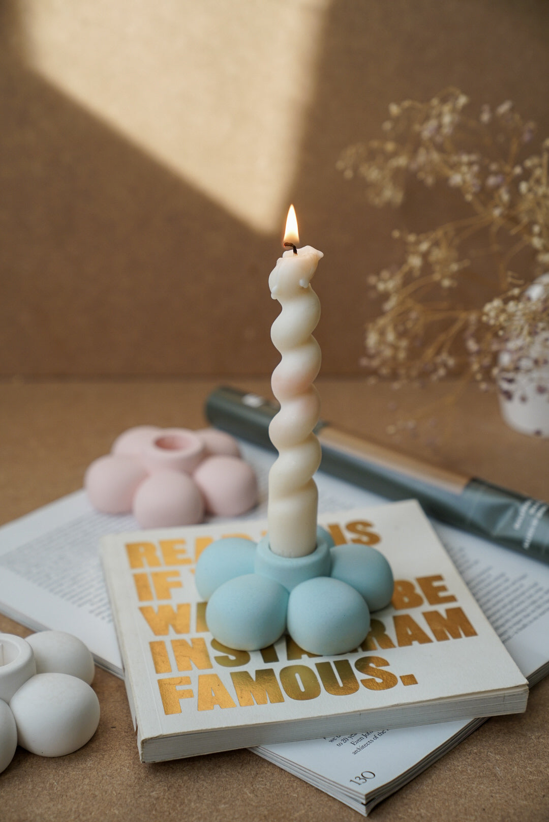 Flower Shaped Candle Holder with twisted burning candle on it.
