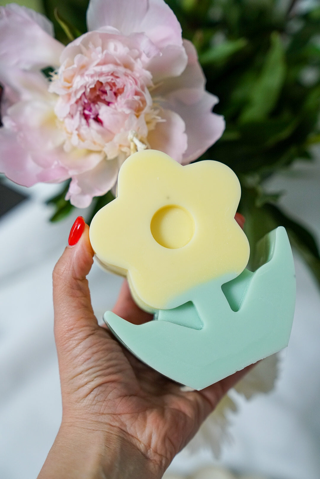 Holding Yellow Flower Pillar Candle with Peonies on the back