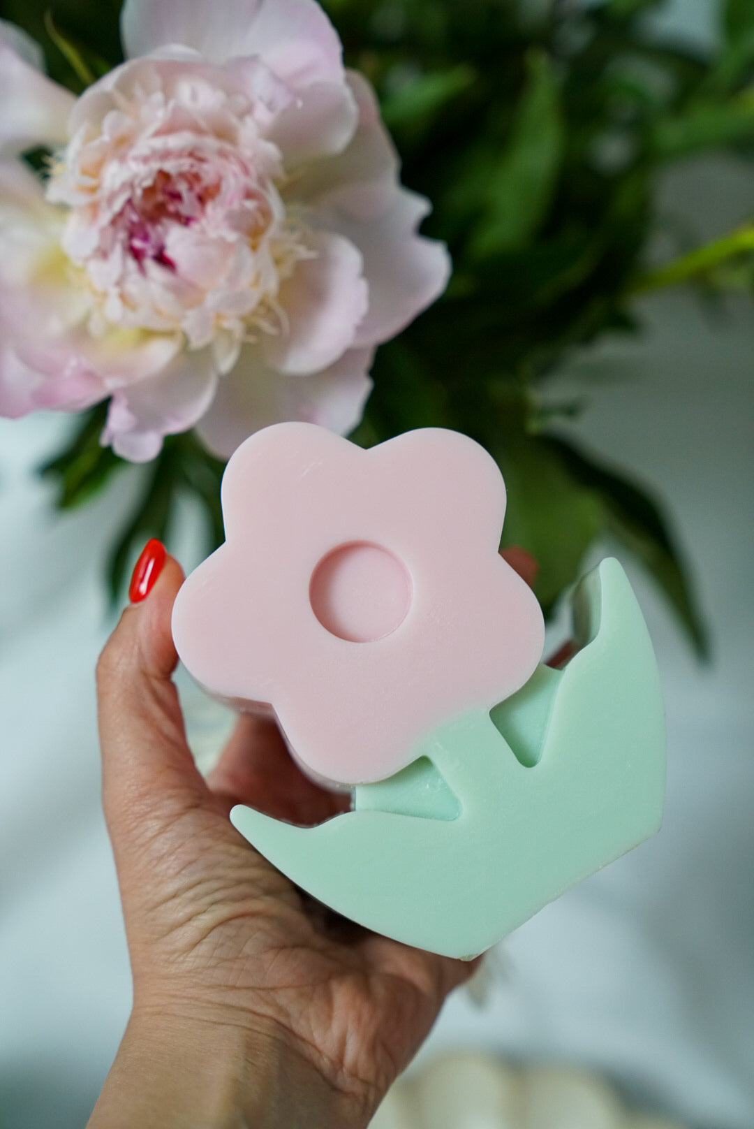 Holding pink Flower Pillar Candle with flowers on the back