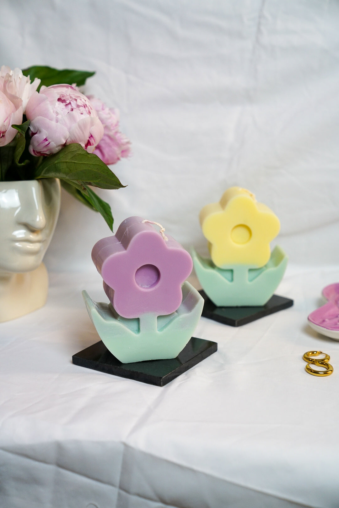 Lavender and Yellow Flower Pillar Candle with face vase on the background peonies in the vase