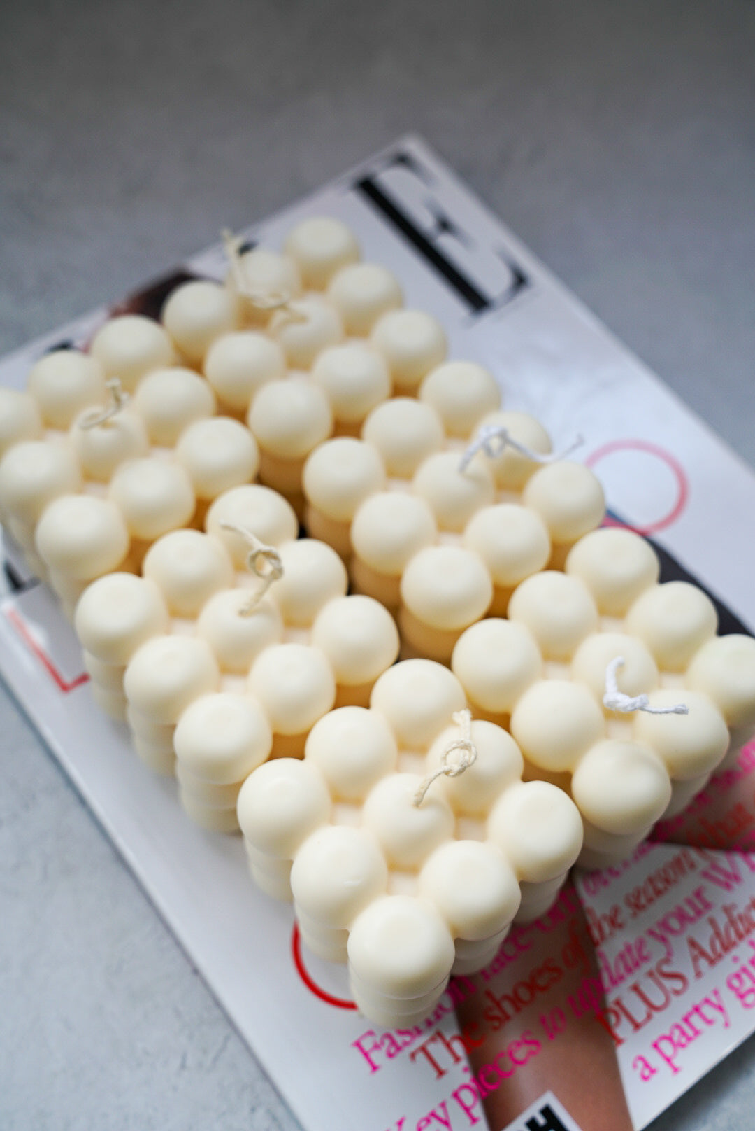 Six white bubble candle with jewellery tray on a magazine