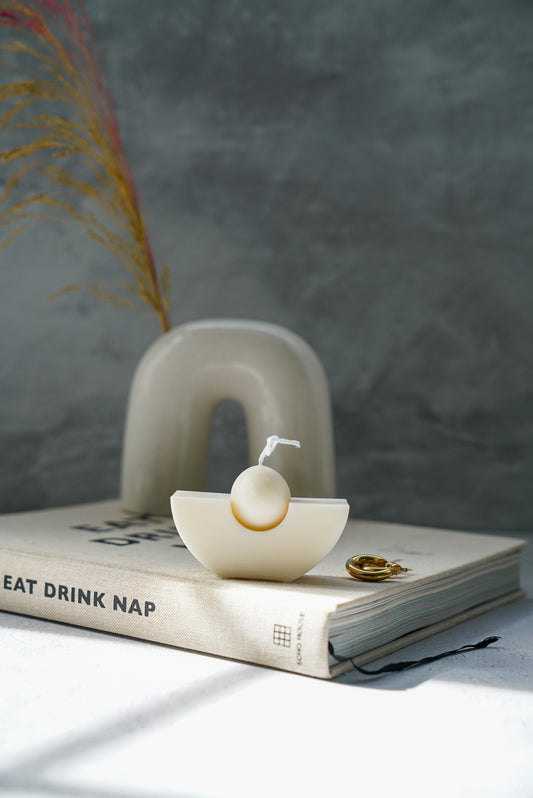 Geometric Candle with vase and dry flowers on the background.