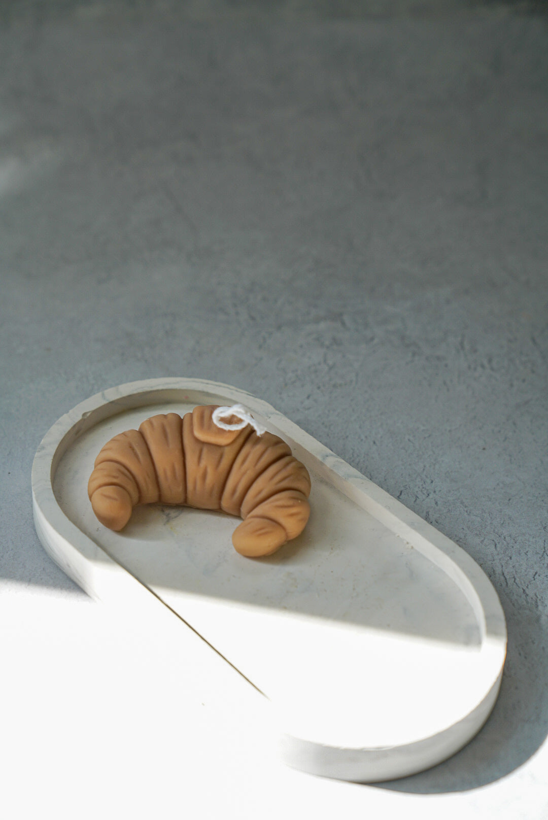 Croissant Shaped Candle on a oval trinket tray.