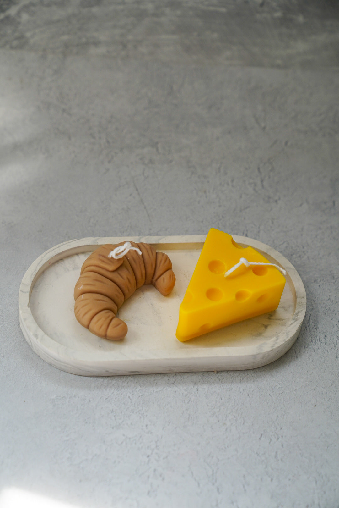 Croissant Shaped Candle and cheese candles on a oval trinket tray.