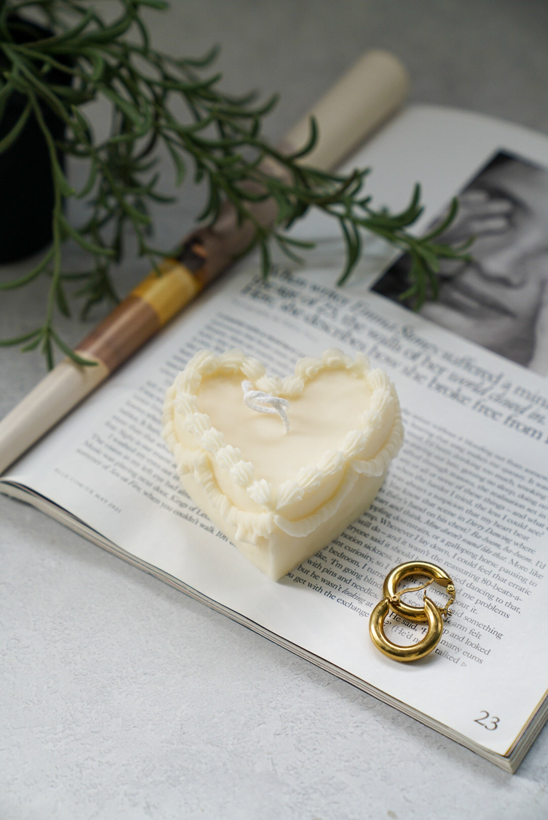 Heart Shape Sweetheart Cake Candle on a magazine earrings next to it.