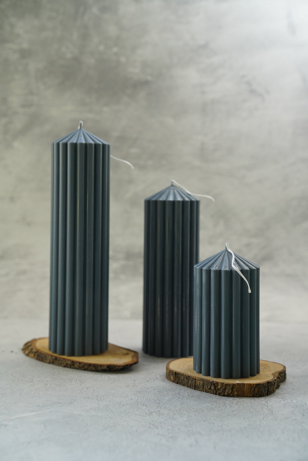 Grey Corinthian Pillar Candle Set on a wooden coaster