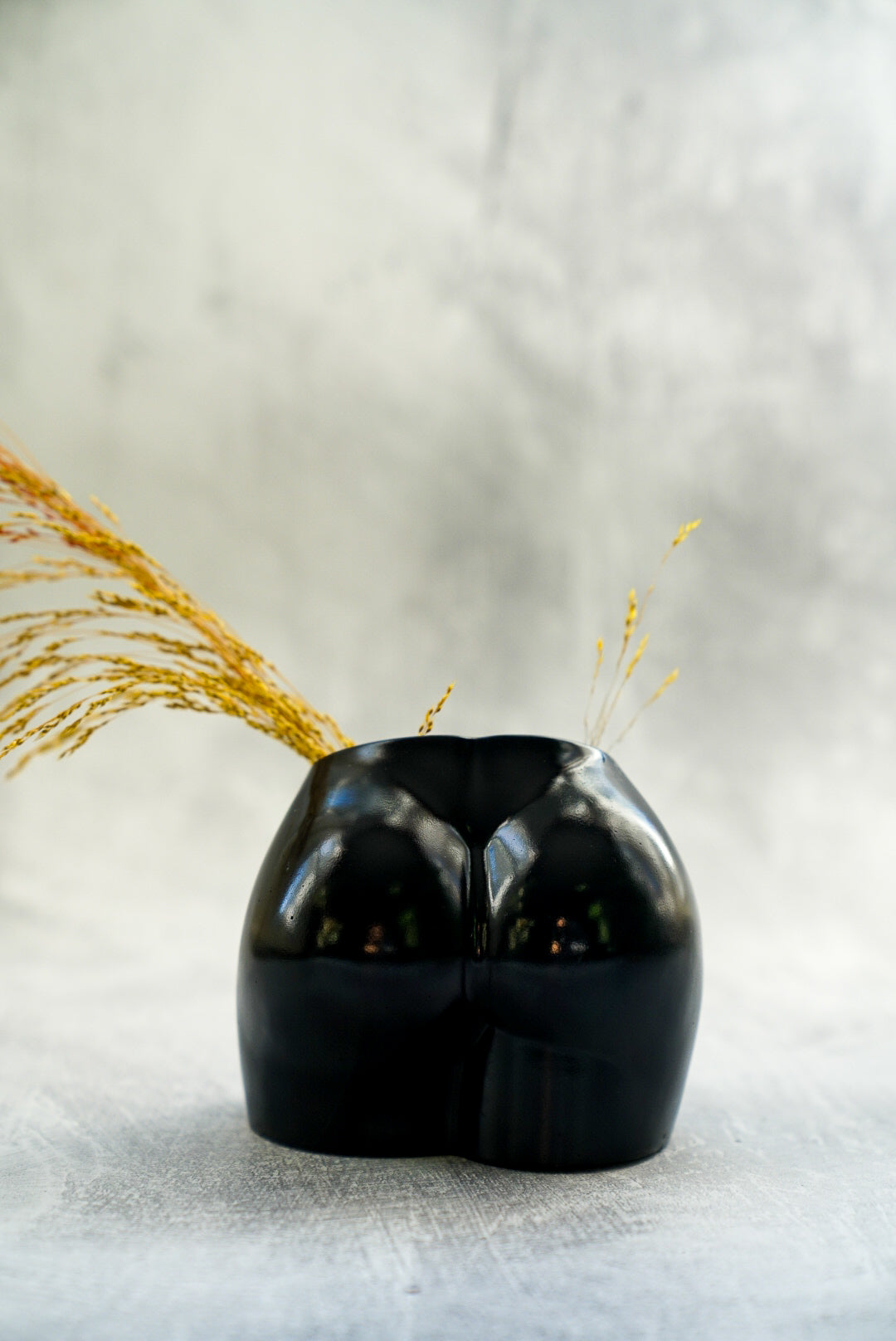 Black Concrete Booty Decorative Vase with dry flowers on it