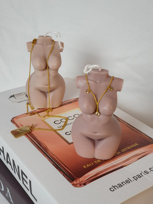 Curvy Goddess Candles with gold necklaces on them.