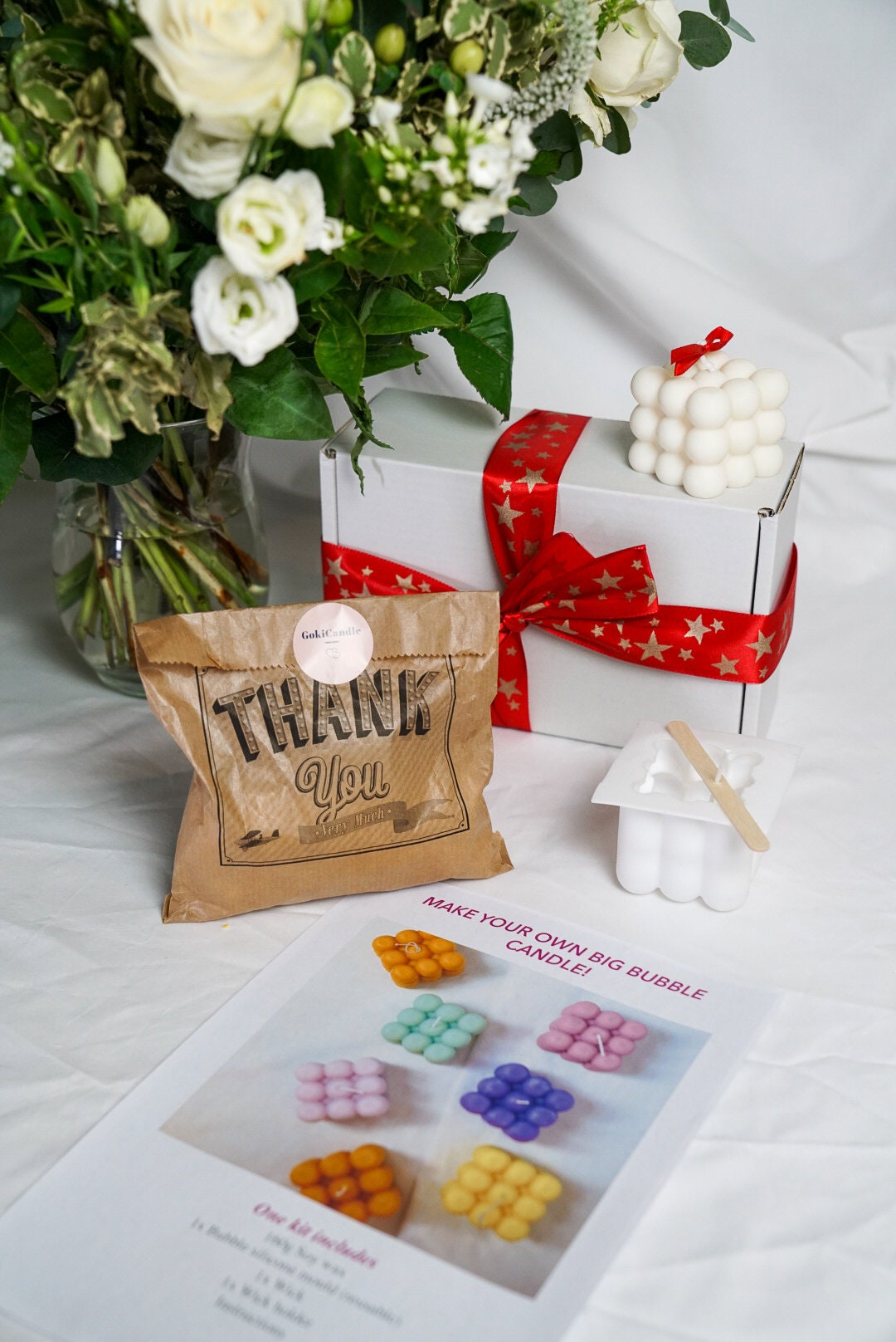 Make your own big Bubble Candle Making Kit with some bubble candles around and flowers on the background.