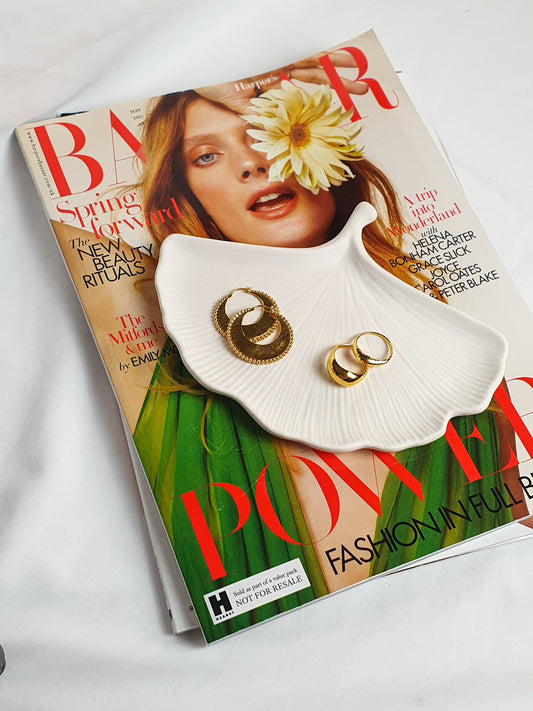 Gingko leaf trinket tray with rings and earrings on it.