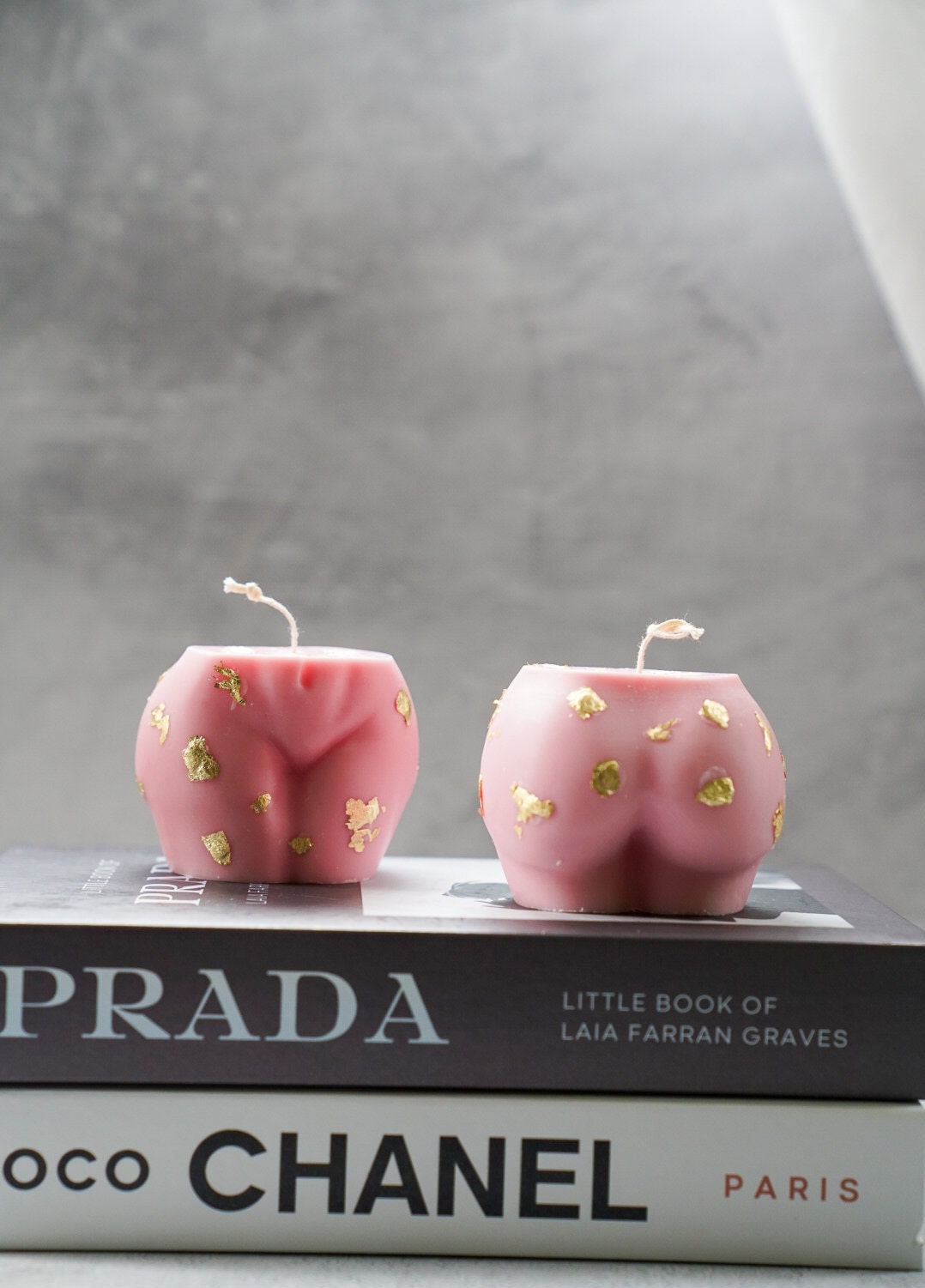 Pink Bum candle with gold details on it.
