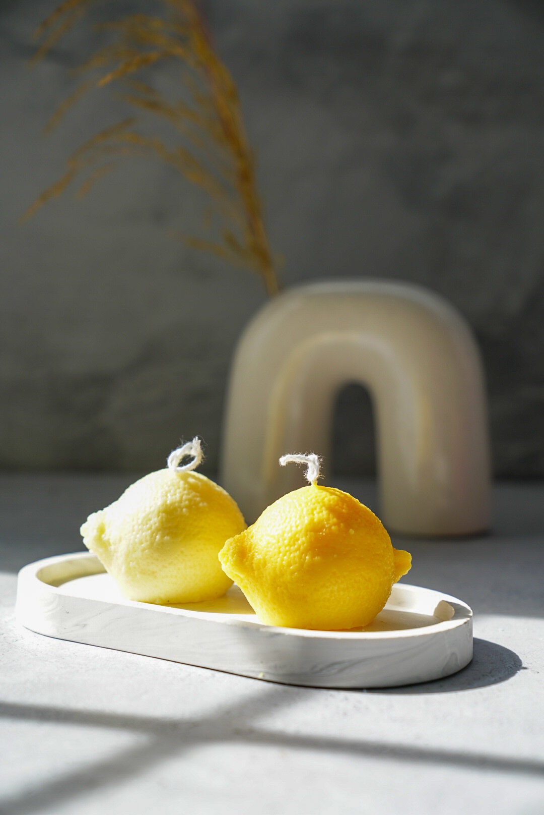 Lemon Shaped Candles on a trinket dish vase on the background.