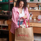 Woman holding a pink bag with 'gokicat' branding in a workshop setting.