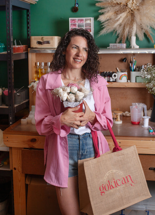 A lady holding Gokican's bag in the studio with flower bouquet candle in the studio